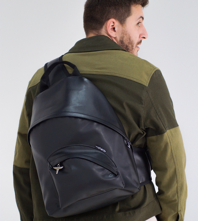 Un homme de dos avec une veste color block verte, porte le sac à dos made in France vegan Pilot Bag. Le 1er sac à dos made in france en raisin au design issu des années 90.