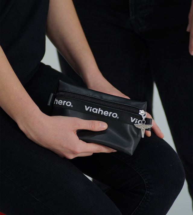 Zoom sur une main féminine qui tient la pochette zippée tendance et urbaine noir, en cuir vegan de raisin made in france. 